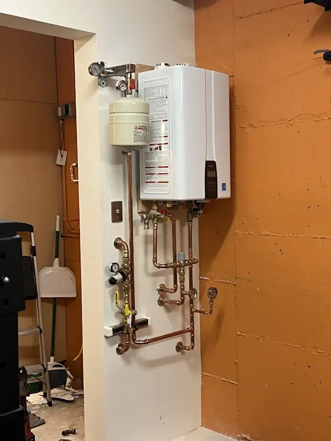 Plumbing technician inspecting water heater connections in Paulden